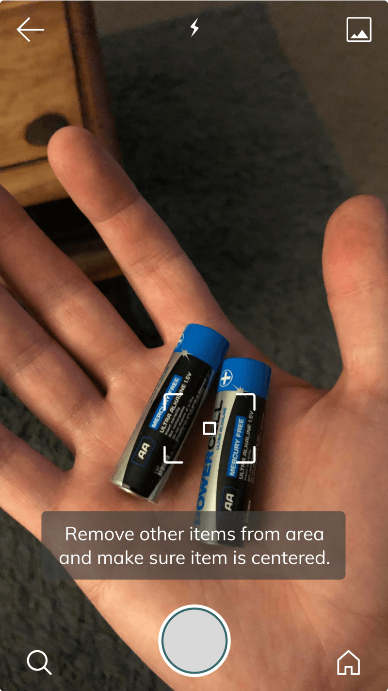Refined camera view with a centering tip overlaid on the live photo of batteries