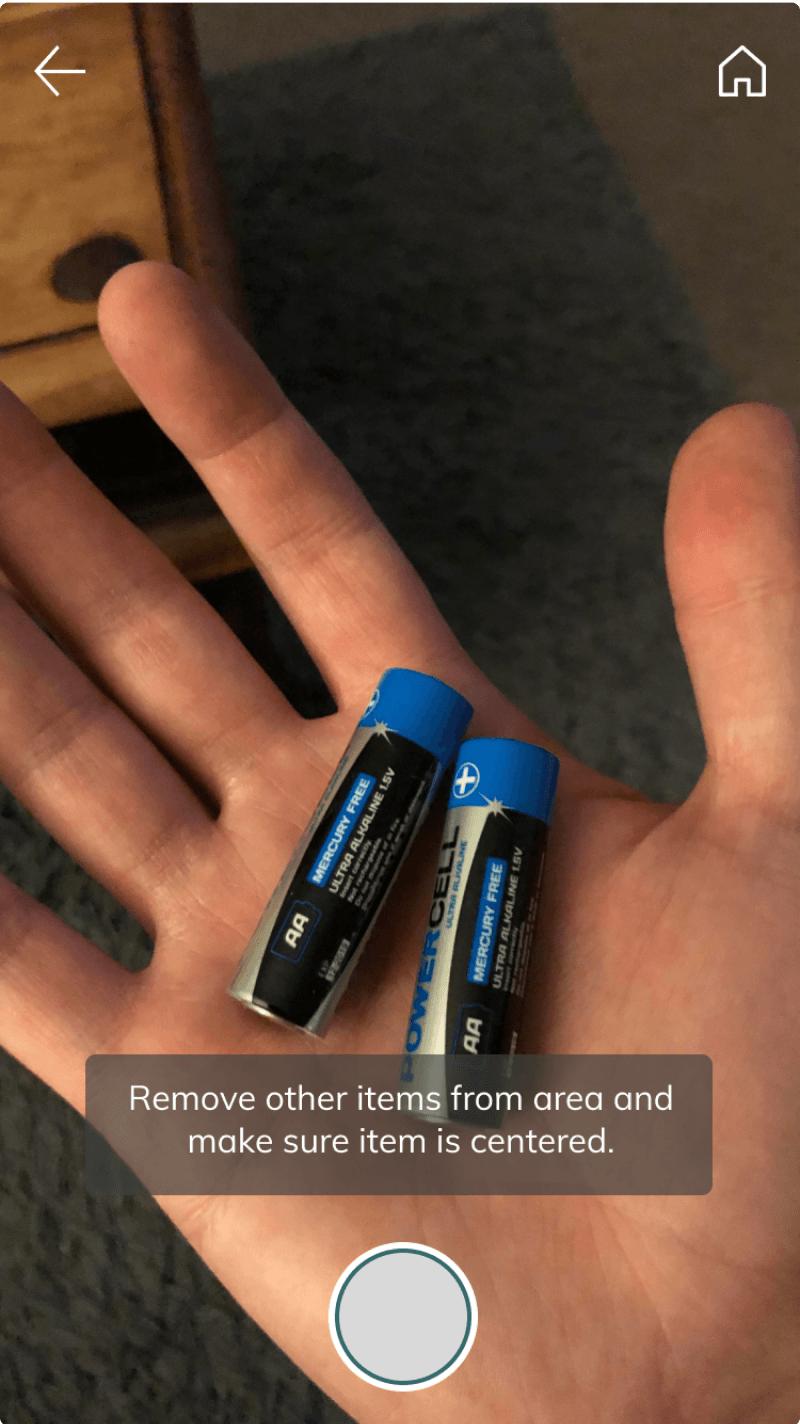 Final camera screen with a centering tip over batteries held in an open hand
